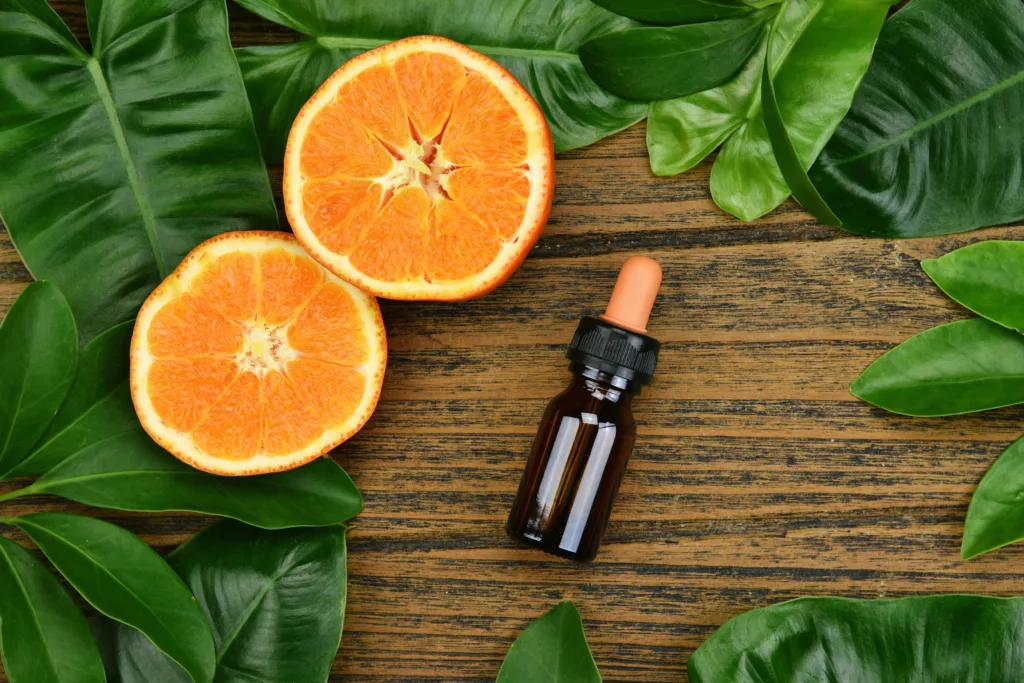 Cosmetics skincare with vitamin-c extract, Cosmetic dropper bottle containers with fresh orange slices, Blank label for branding mock-up, Natural Vitamin C beauty product concept